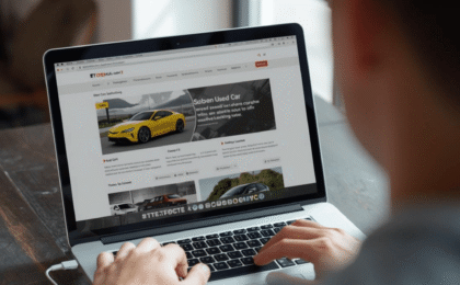 Uomo davanti al computer che consulta un annuncio di auto usata